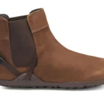A brown ankle-high leather Chelsea Boot from Xero Shoes with a pull tab at the back, elastic side panel, and dark rubber sole. This stylish design also features a small strap detail near the heel for contemporary flair.