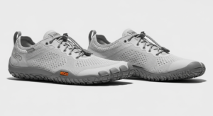 A pair of light grey barefoot-style athletic shoes from Xero Shoes, featuring textured soles, lace-up fronts, and a small orange "V-TRAIL" label on the side—showcasing quality craftsmanship on a plain white background.